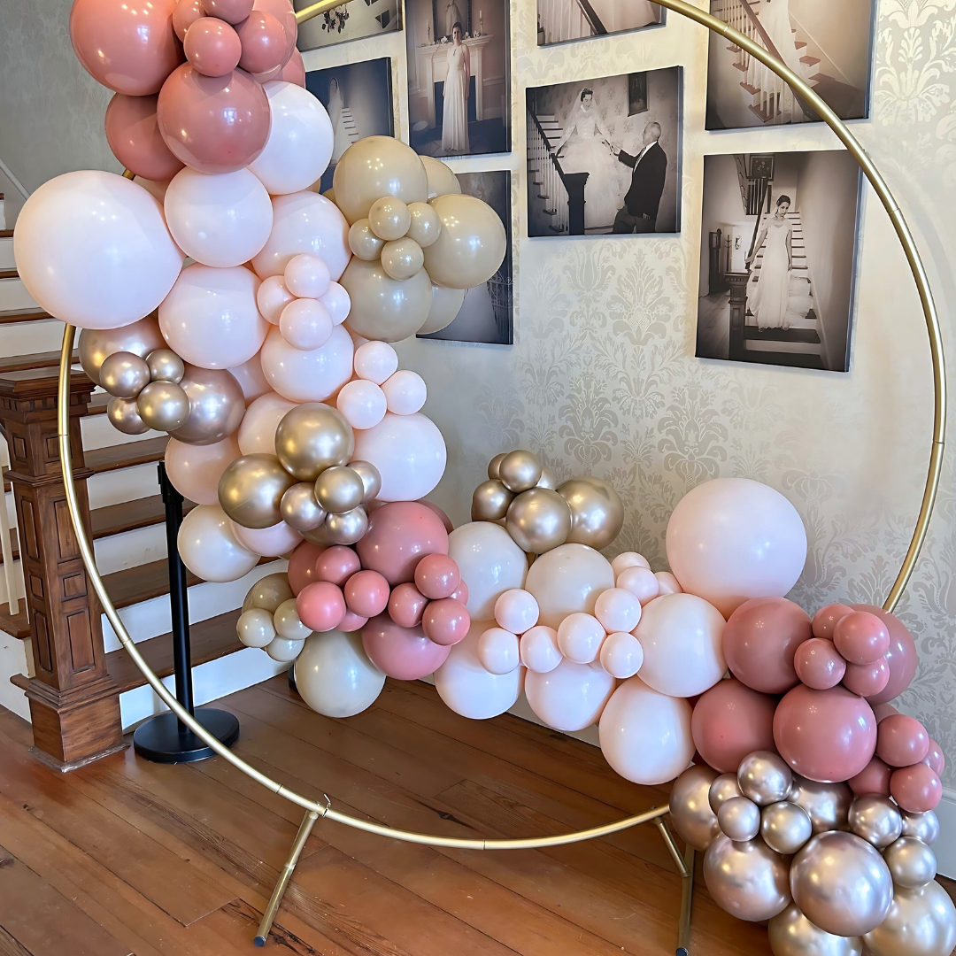 Gold hoop balloon backdrop with an organic balloon garland, perfect for weddings, birthdays, and special events. Elegant and modern balloon decor.
